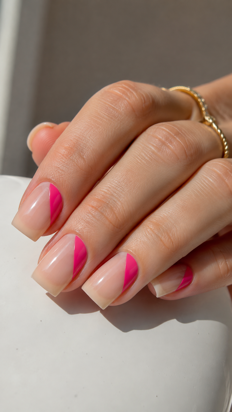 Hot pink negative space nail art, minimal geometric manicure idea.